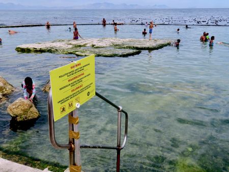 Some beachgoers undeterred by health warnings as Cape Town blames rolling blackouts for sewage spills